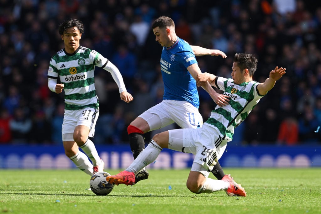 Tom Lawrence of Rangers is tackled by Tomoki Iwata of Celtic during the Cinch Scottish Premiership match between Rangers FC and Celtic FC at Ibrox ...