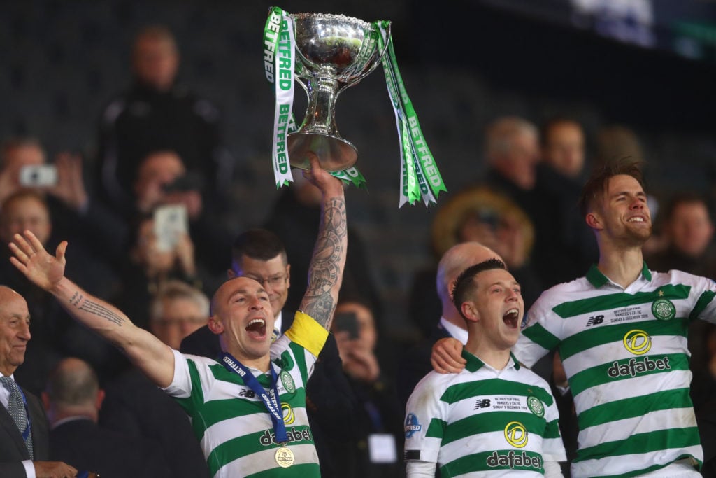 Scott Brown of Celtic raises aloft the Betfred Cup alongside Callum McGregor and Kristoffer Ajer during the Betfred Cup Final between Rangers FC an...